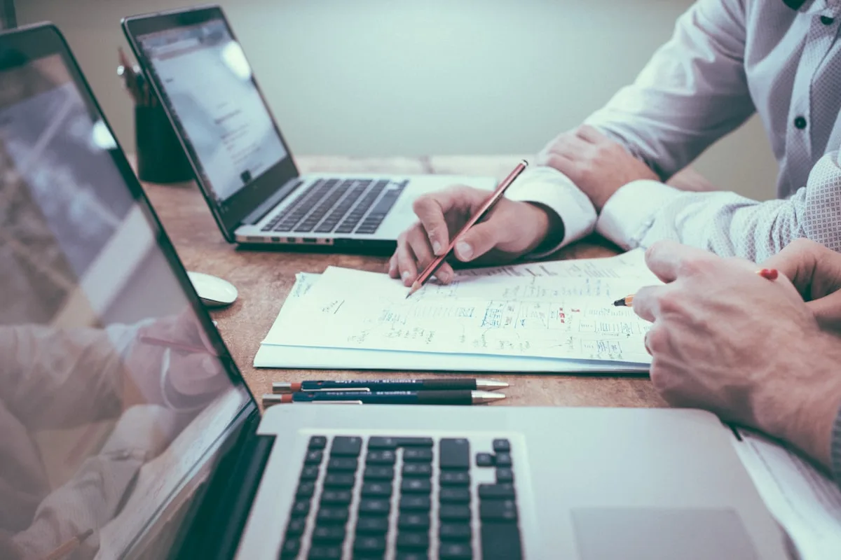 Espace de travail d'un conseiller en gestion de patrimoine immobilier avec plans architecturaux