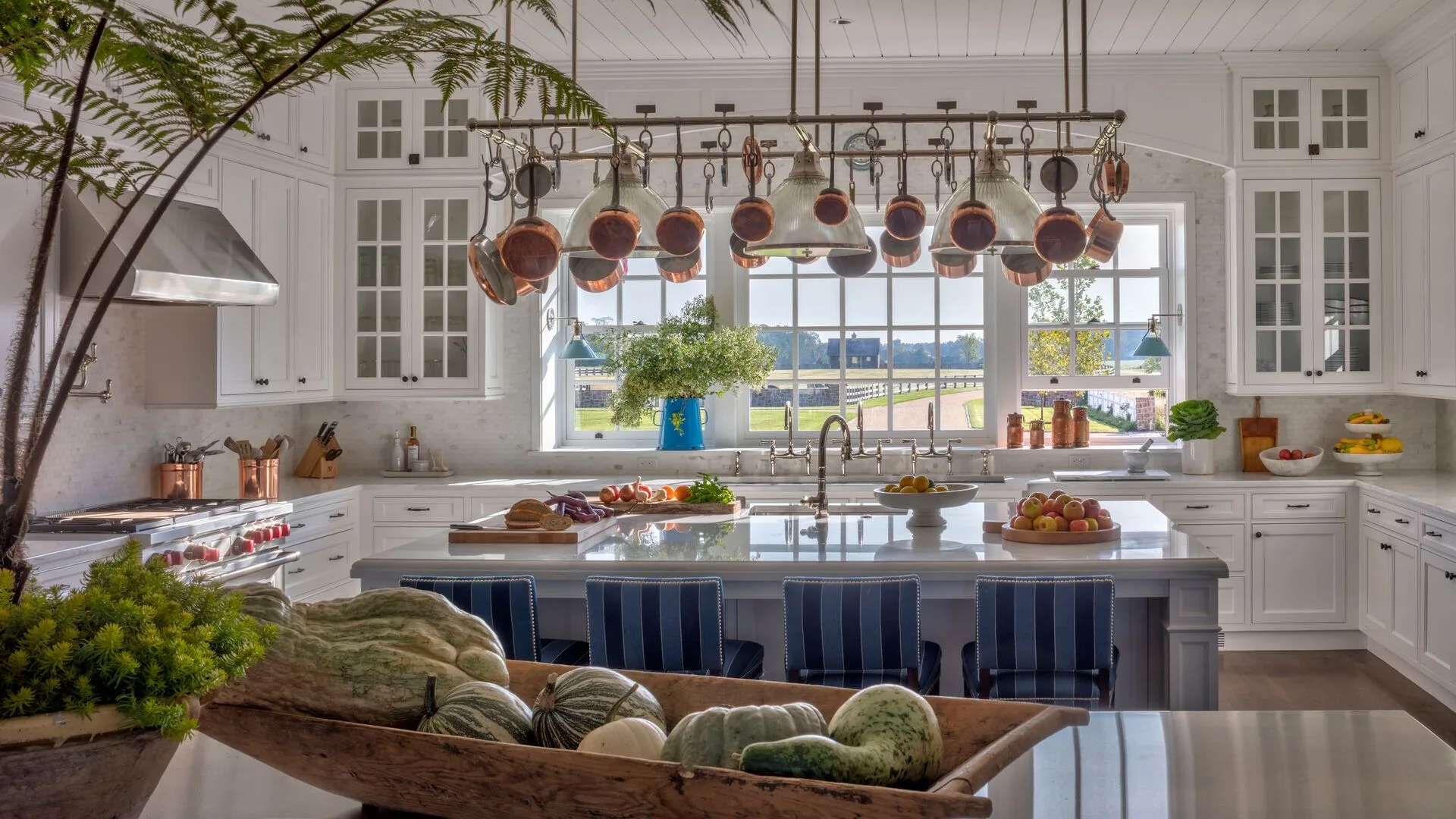 Chef privé préparant un repas gastronomique dans la cuisine d'une villa de luxe avec concierge en arrière-plan
