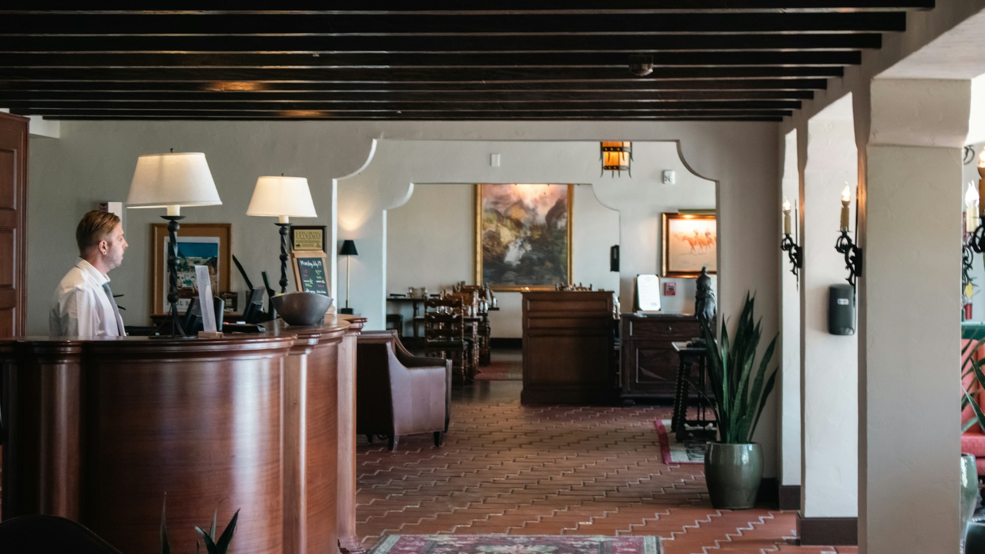 Modern concierge command centre with professional at screens showing property management dashboards and world map