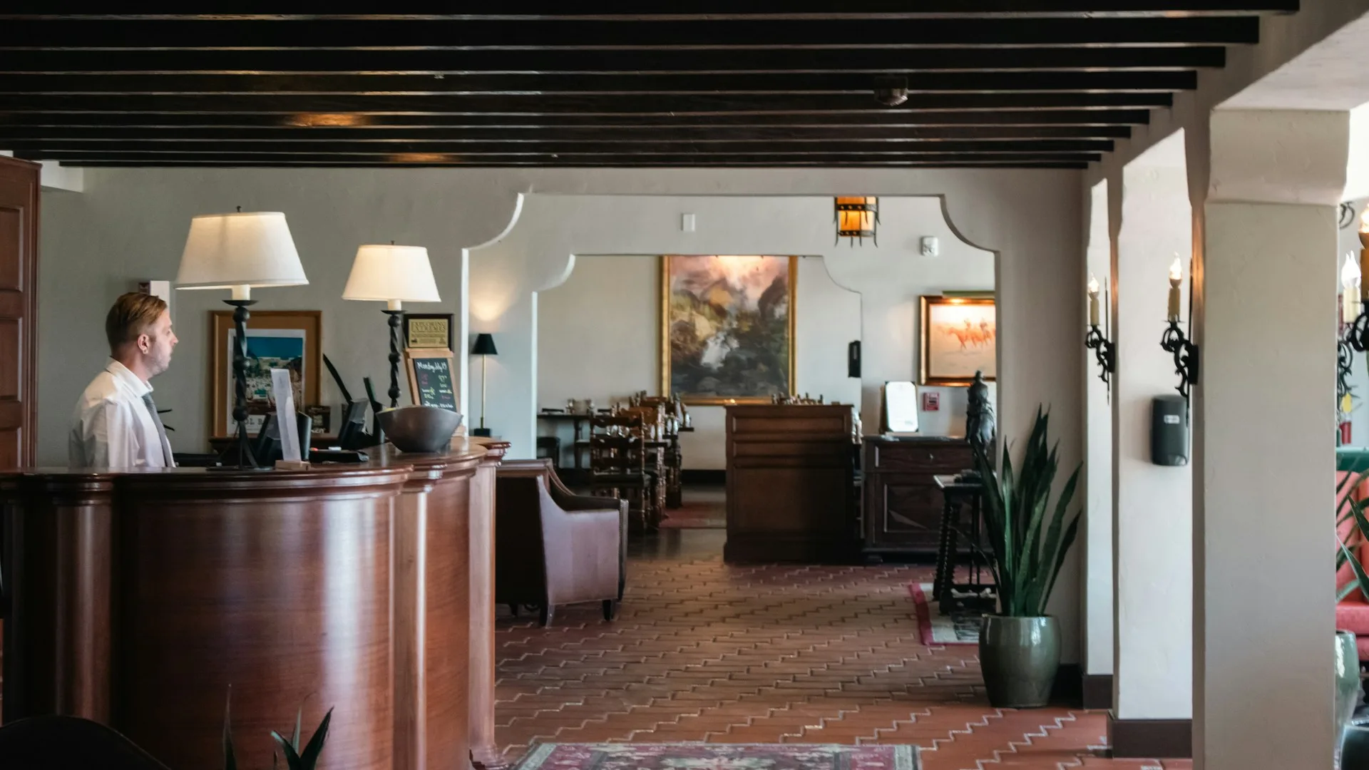 Modern concierge command centre with professional at screens showing property management dashboards and world map